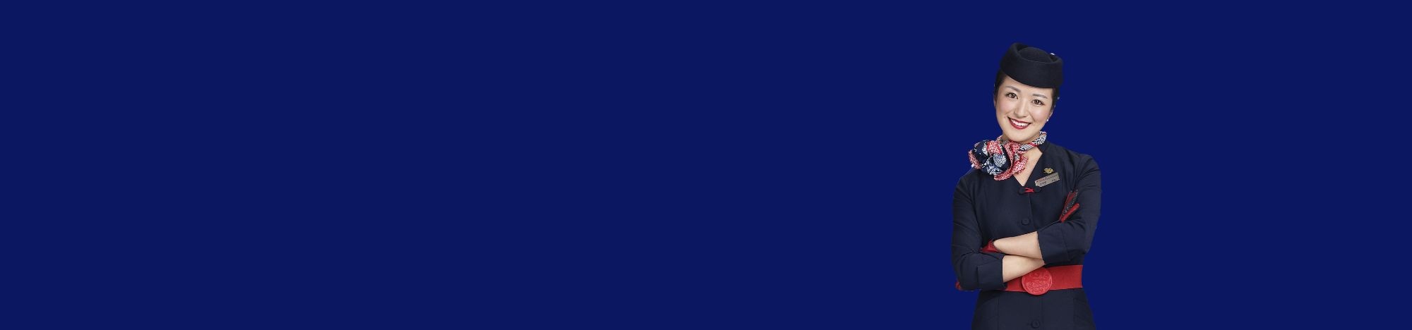 Persona uniformada sonríe con brazos cruzados, fondo azul liso.