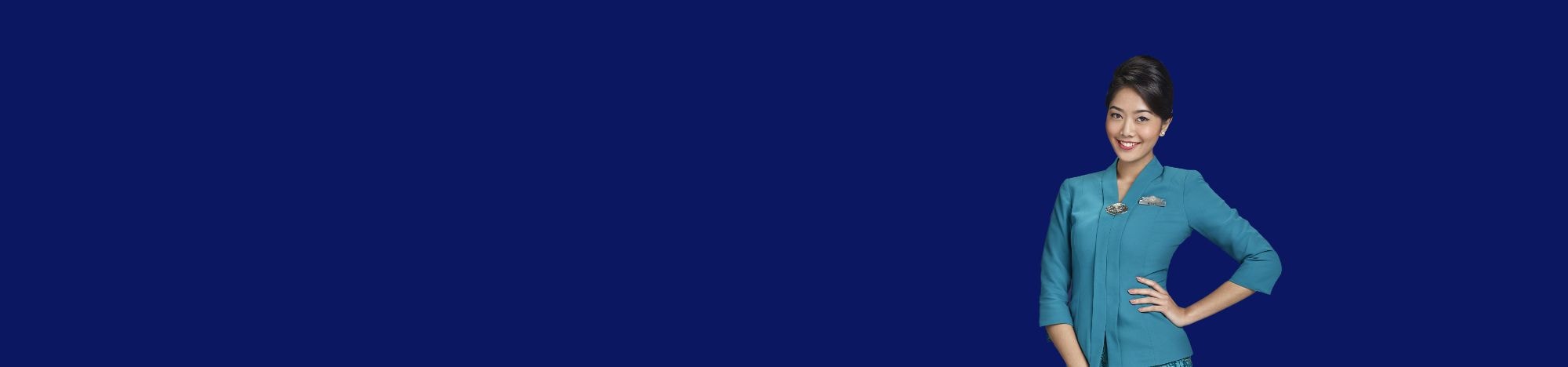 Una persona sonríe vistiendo uniforme azul, sobre fondo azul oscuro liso.