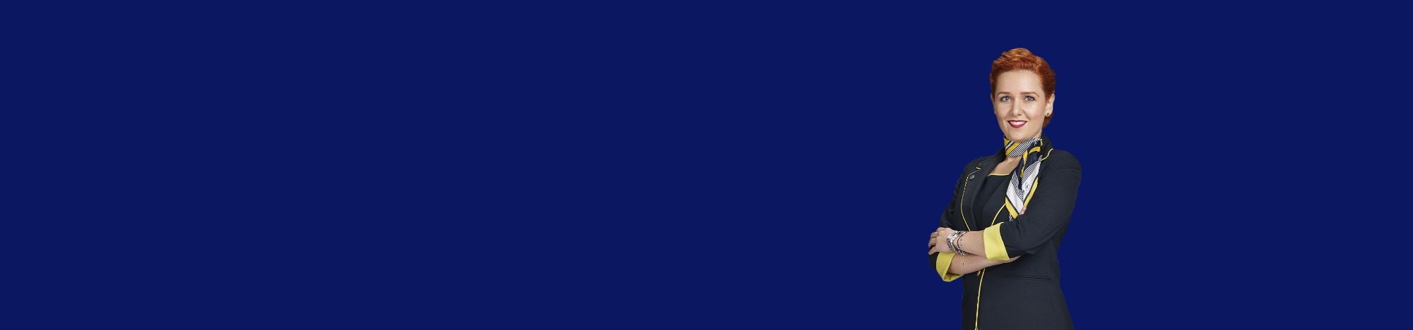 Persona de pie, brazos cruzados, fondo azul oscuro.