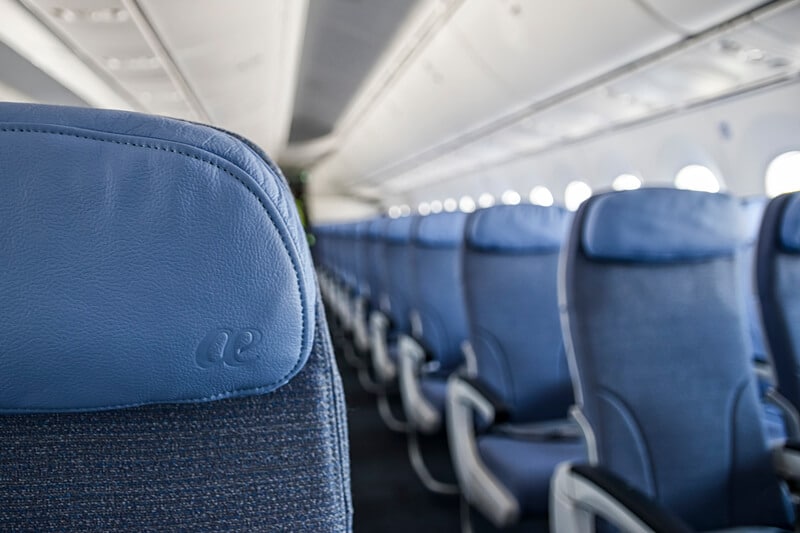 <span class='text-nowrap'>Air Europa</span> seats Empty blue airplane seats, lined up in rows, inside the well-lit cabin.